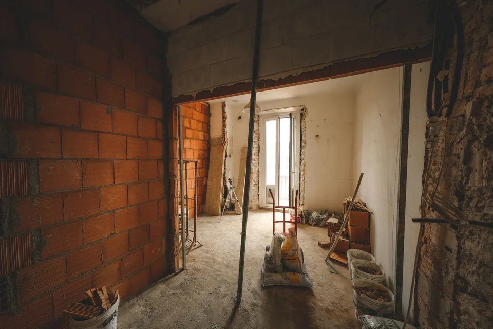 Logement ancien en cours de rénovation, cloison en brique et matériaux au sol